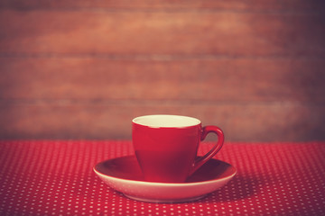 Cup of a coffee on polka dot cover.