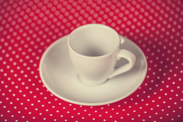 Cup of a coffee on polka dot cover.