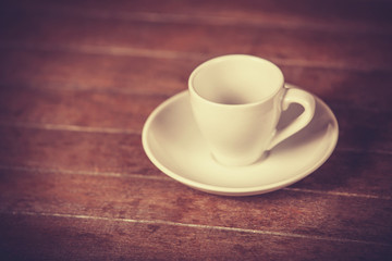 Little and empty cup for a coffeeor tea on a wooden table