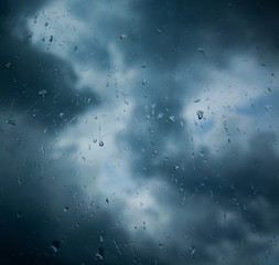 Rain drops on window across clouds