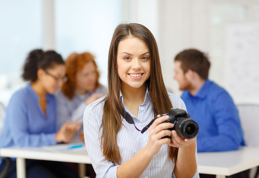 smiling female photographer with photocamera