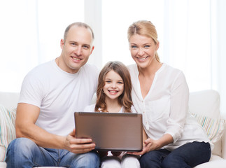 parents and little girl with laptop at home
