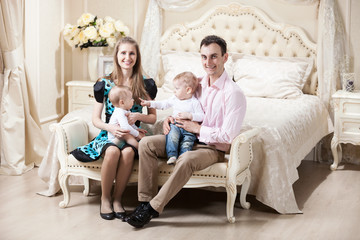 Young happy family with two baby boys at home
