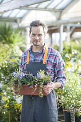 professional gardener posing with a flower pot in her arms in a