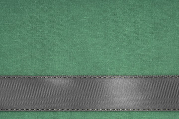 Fototapeta premium Gray ribbon on green fabric background with copy space.