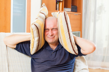 Angry man covering his ears