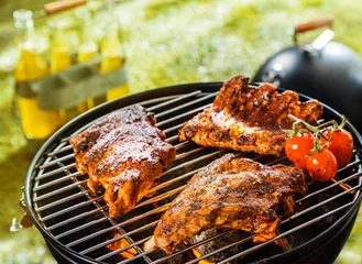 Photo sur Plexiglas Grill / Barbecue Three spicy racks of rib cooking on a BBQ fire