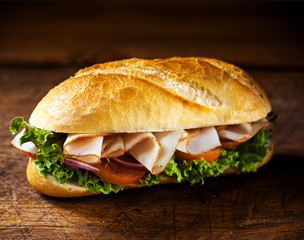 Crusty roll with sliced ham and salad ingredients