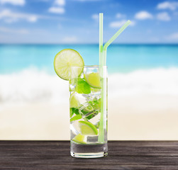 Glass of mojito cocktail on a beach