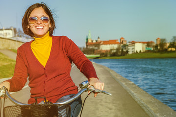 Obraz premium Happy woman riding by bysicle along waterfront