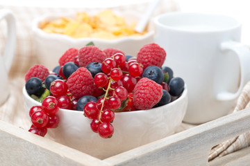 fresh berries, corn flakes and milk on a tray