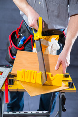 Man sawing wood for home renovation