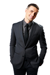 Fototapeta premium Smiling businessman standing isolated on a white background