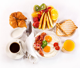 Breakfast with fried eggs, coffee,  juice, croissant and fruits