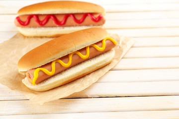 Tasty hot dogs on wooden table