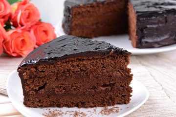 Delicious chocolate cake on plate on table close-up