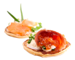 Pancakes with red caviar and salmon,  isolated on white