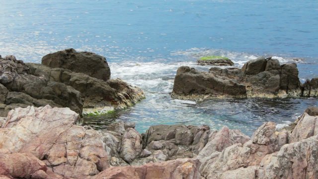 sea wave breaks about boulders