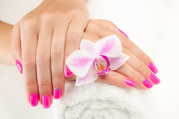 Obraz na płótnie Canvas beautiful manicure with pink orchid on the white