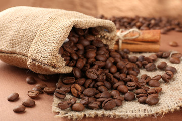 Coffee beans in sack on table close-up