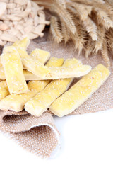 Tasty bread sticks on sackcloth isolated on white
