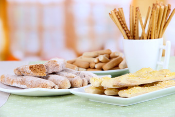 Variety of bread sticks on table, on bright background