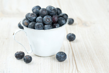 blueberries in a metallic cup on wooden table