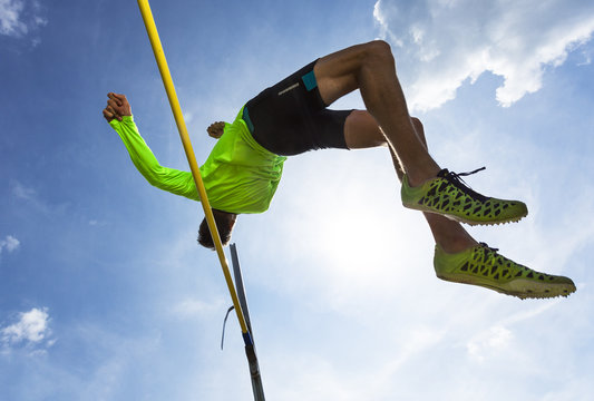 Germany, Man athlete jumping Hurdles on track