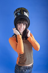 Cheerful girl in a hat on a blue background