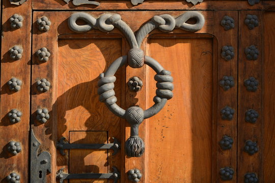 Dise&ntilde;o artistico de aldaba en puerta de madera con ornamento