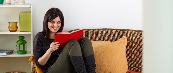 Brunette woman reading a book ,at living room