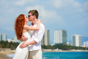 Obraz premium Romantic couple kissing on the beach.