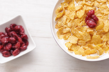 Bowl of milk with corn flakes seasoned with cranberries