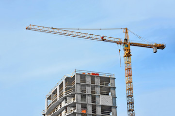 Crane and building construction site against blue sky