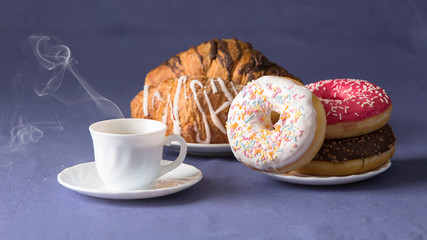 Cup of coffee with croissants and donuts