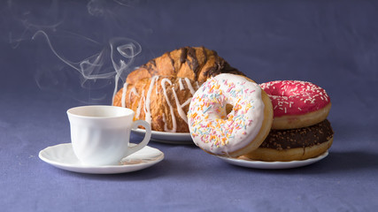Cup of coffee with croissants and donuts
