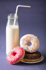 Donut with milk at violet background