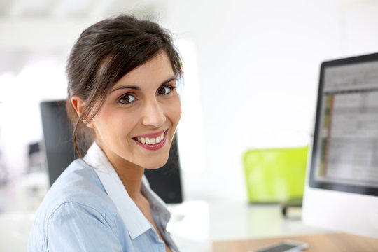 Smiling office worker sitting at desk