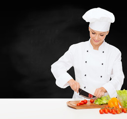 smiling female chef chopping vagetables