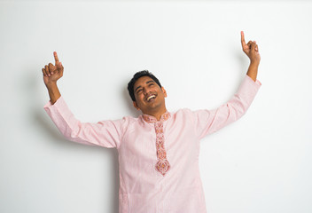 young indian male in traditional cloths celebrating bhangra