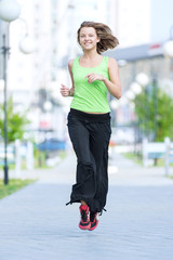 Naklejka premium Woman jogging in city street park.