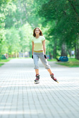 Roller skating sporty girl in park rollerblading on inline skate