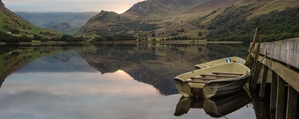 Panorama landscape rowing boats on lake with jetty against mount © veneratio