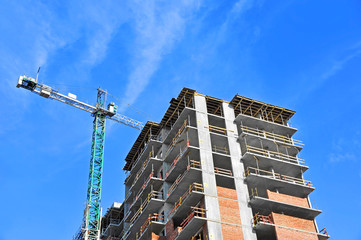 Naklejka premium Crane and building construction site against blue sky