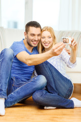 smiling couple taking picture with digital camera