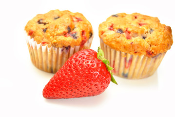 Whole Strawberry in Front of Two Berry Muffins