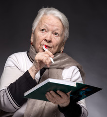 Senior woman writing notes in a notebook