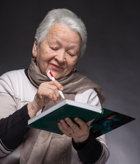 Senior woman writing notes in a notebook