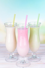 Milk shakes on table on light blue background