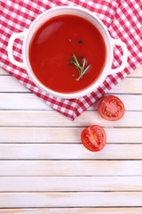 Tasty tomato soup on wooden table